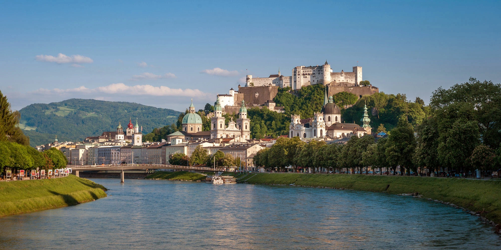 Blick über die Salzach auf die Altstadt von Salzburg mit der Festung Hohensalzburg im Hintergrund.