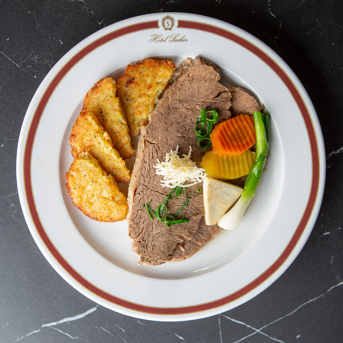 Zart gegarter Tafelspitz, liebevoll angerichtet mit Kren, buntem Wurzelgemüse und knusprigen Rösti