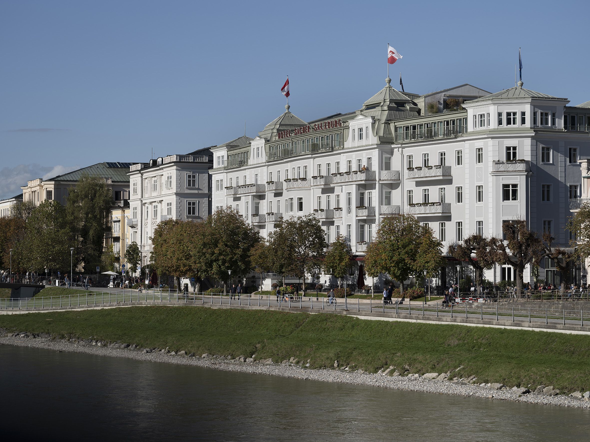 Hotel Sacher Salzburg am Tag von der gegenüberliegenden Seite der Salzach.