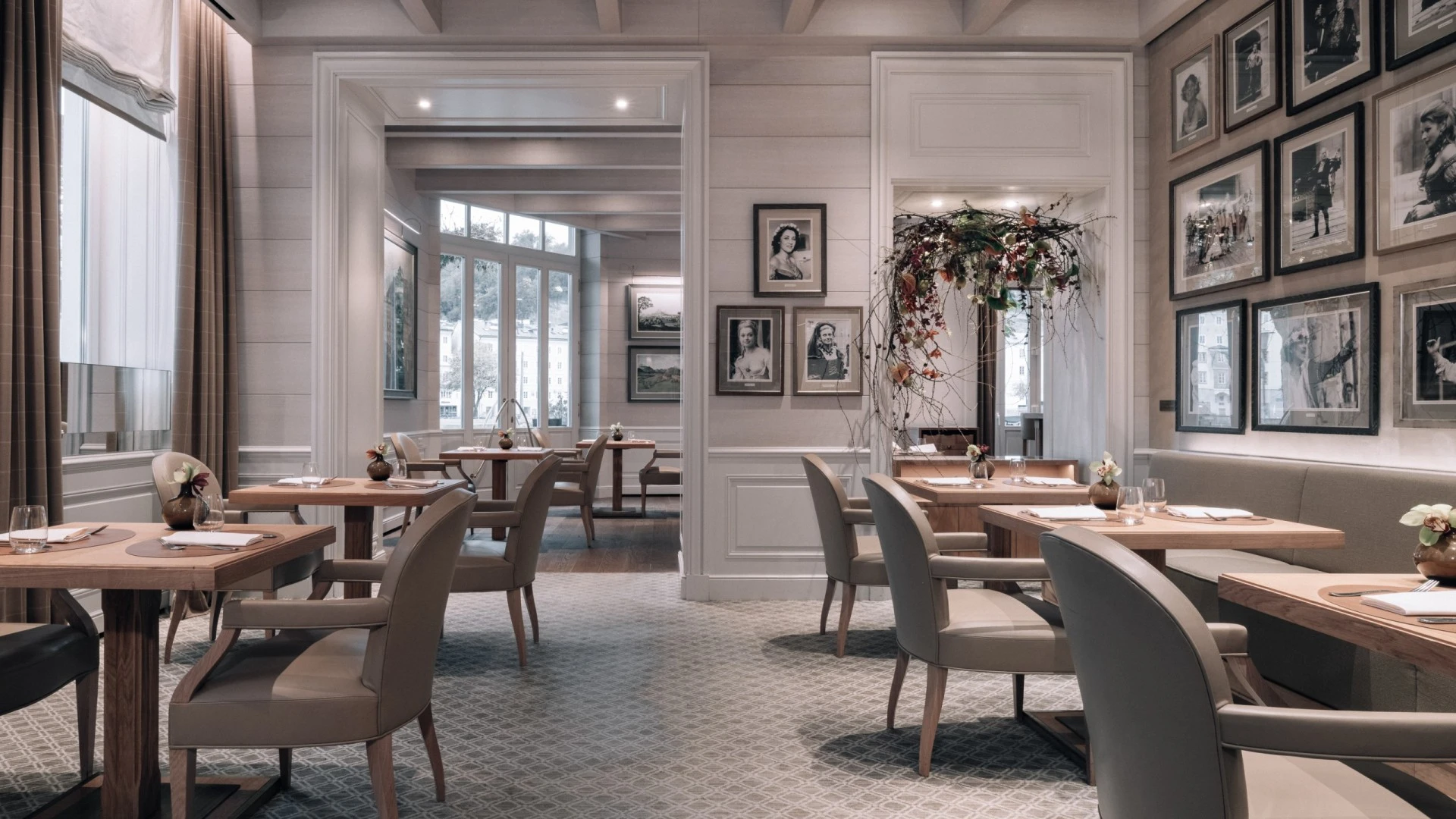 Helles, elegant eingerichtetes Restaurant mit modern-klassischem Stil. Die Möbel sind aus hellem Holz, kombiniert mit bequemen, hellgrauen Polsterstühlen. Große Fenster sorgen für viel Tageslicht und einen schönen Ausblick