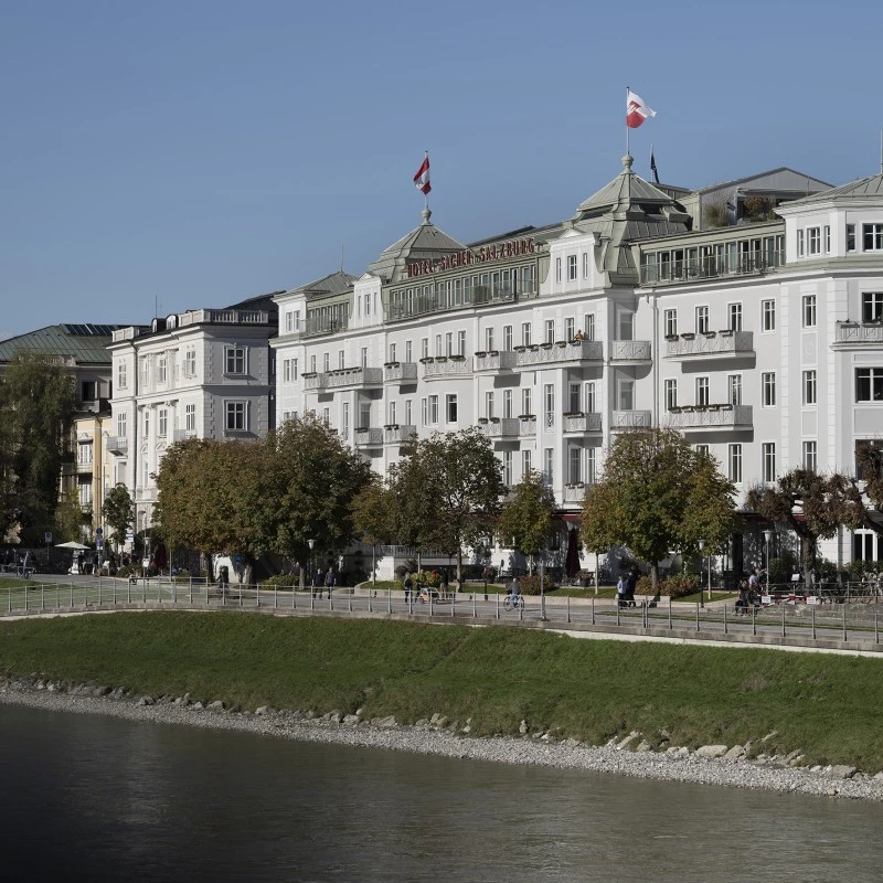 Hotel Sacher Salzburg am Tag von der gegenüberliegenden Seite der Salzach.