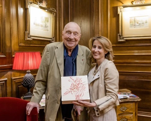 Alexandra Winkler steht neben dem Künstler Georg Baselitz und hält die von ihm gestaltete Holzbox der Original Sacher-Torte aus der Artist Collection.