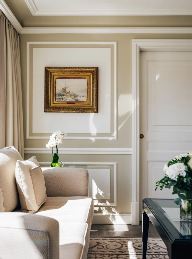 Eleganter Wohnbereich mit beigem Sofa, Couchtisch mit frischem Blumenstrauß.