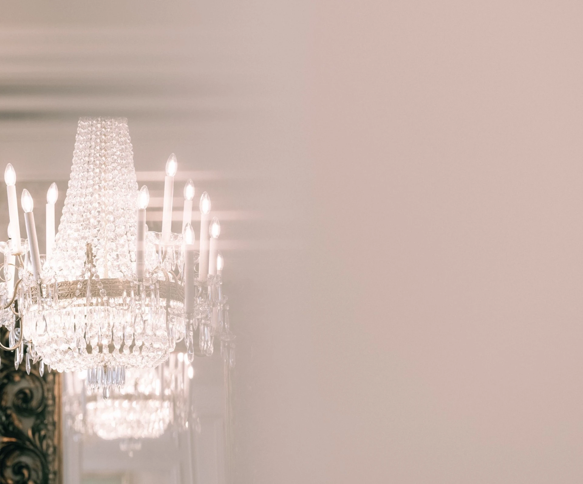 Detailaufnahme eines funkelnden Kristall-Lusters im Hotel Sacher, dessen Lichtspiel sanft an der Wand reflektiert wird.