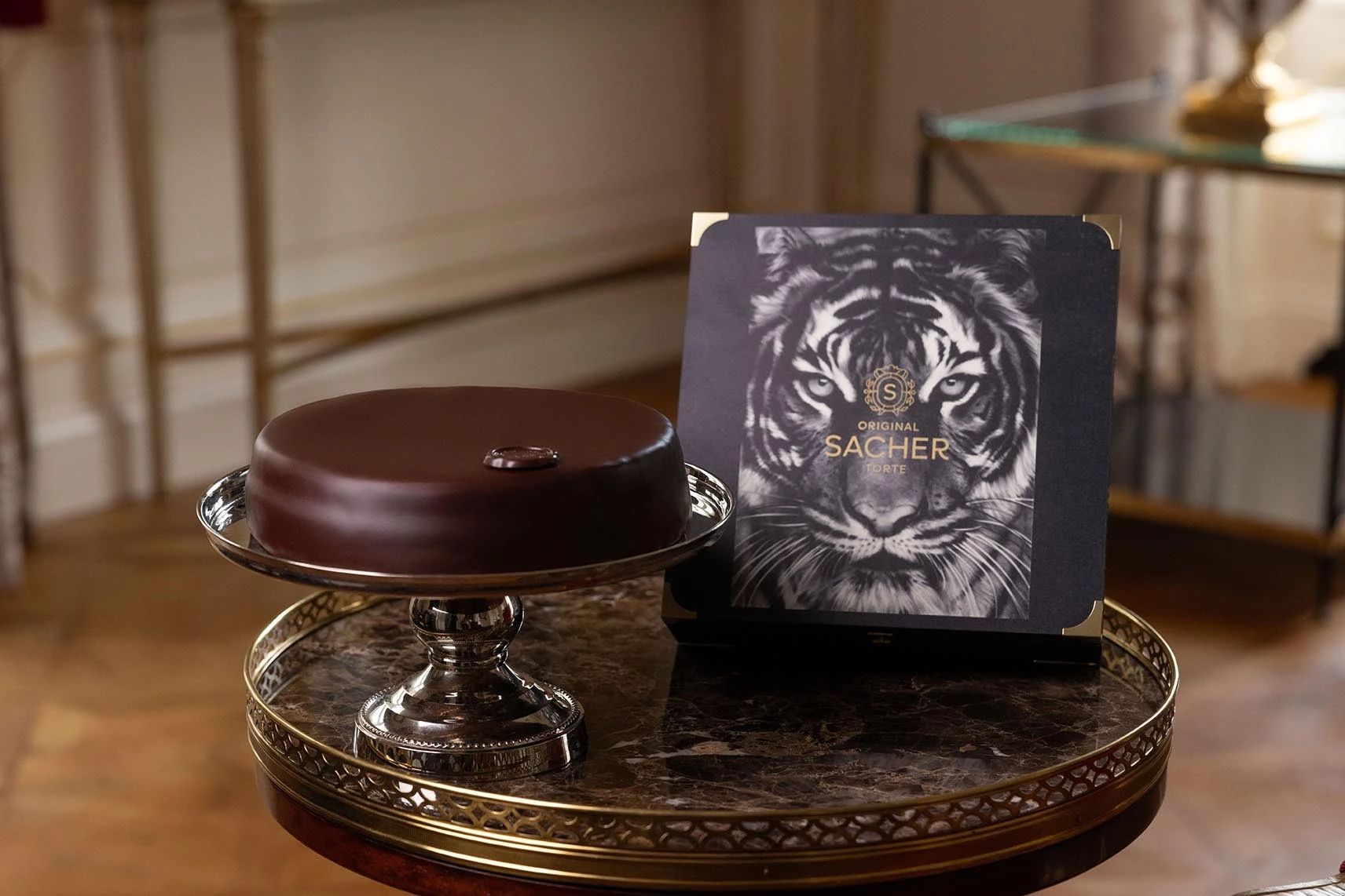 Links die Original Sacher-Torte, rechts daneben die Holzbox der limitierten Artists Collection von Robert Longo mit dem Tiger-Motiv