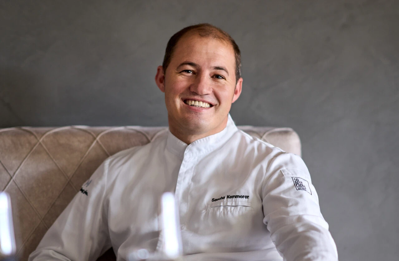 Chef Sascha Kemmerer sitzt lächelnd in einem Stuhl