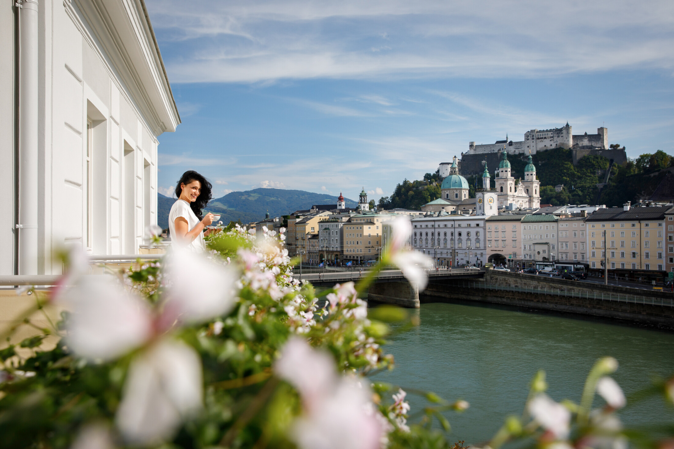 Genussvoller Moment auf dem Balkon mit Blick auf die Salzburger Altstadt und die Festung Hohensalzburg – Eleganz trifft Panorama.