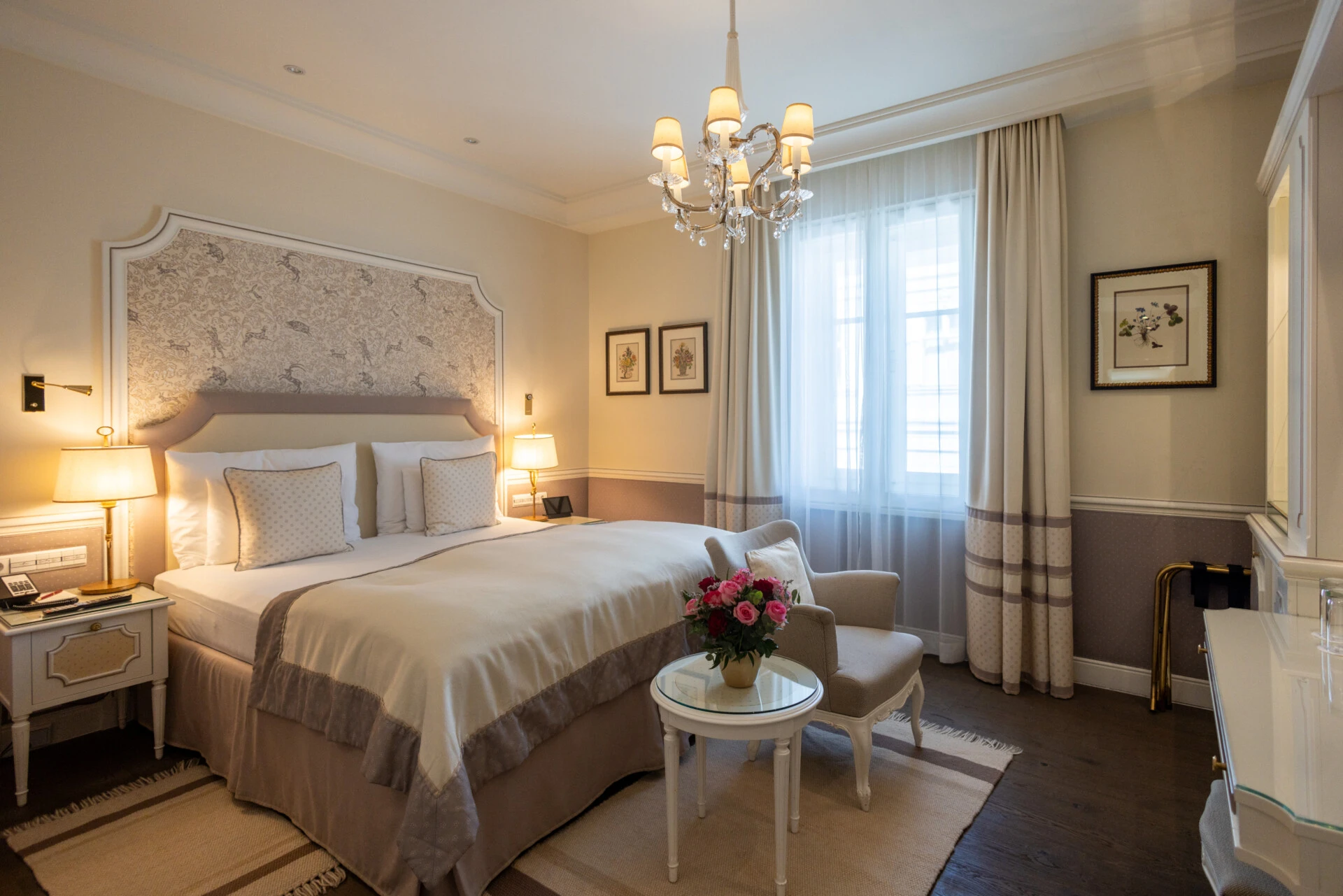 Elegantes Doppelzimmer im Hotel Sacher mit Kronleuchter, gemütlichem Sessel und Tageslichtfenster