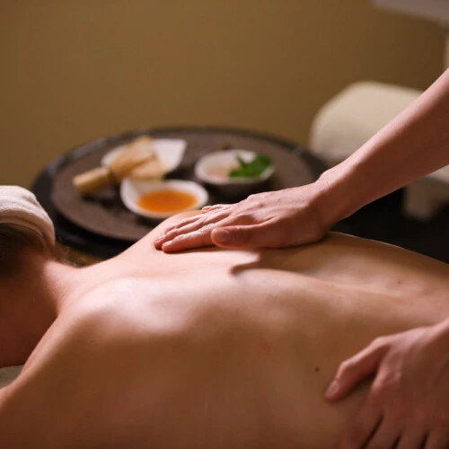 Entspannende Rückenmassage in ruhiger Spa-Atmosphäre mit wohltuenden Ölen und natürlichen Essenzen.