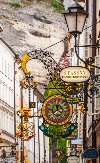 Historische Getreidegasse in Salzburg mit kunstvollen schmiedeeisernen Geschäftsschildern und engen Altstadtfassaden