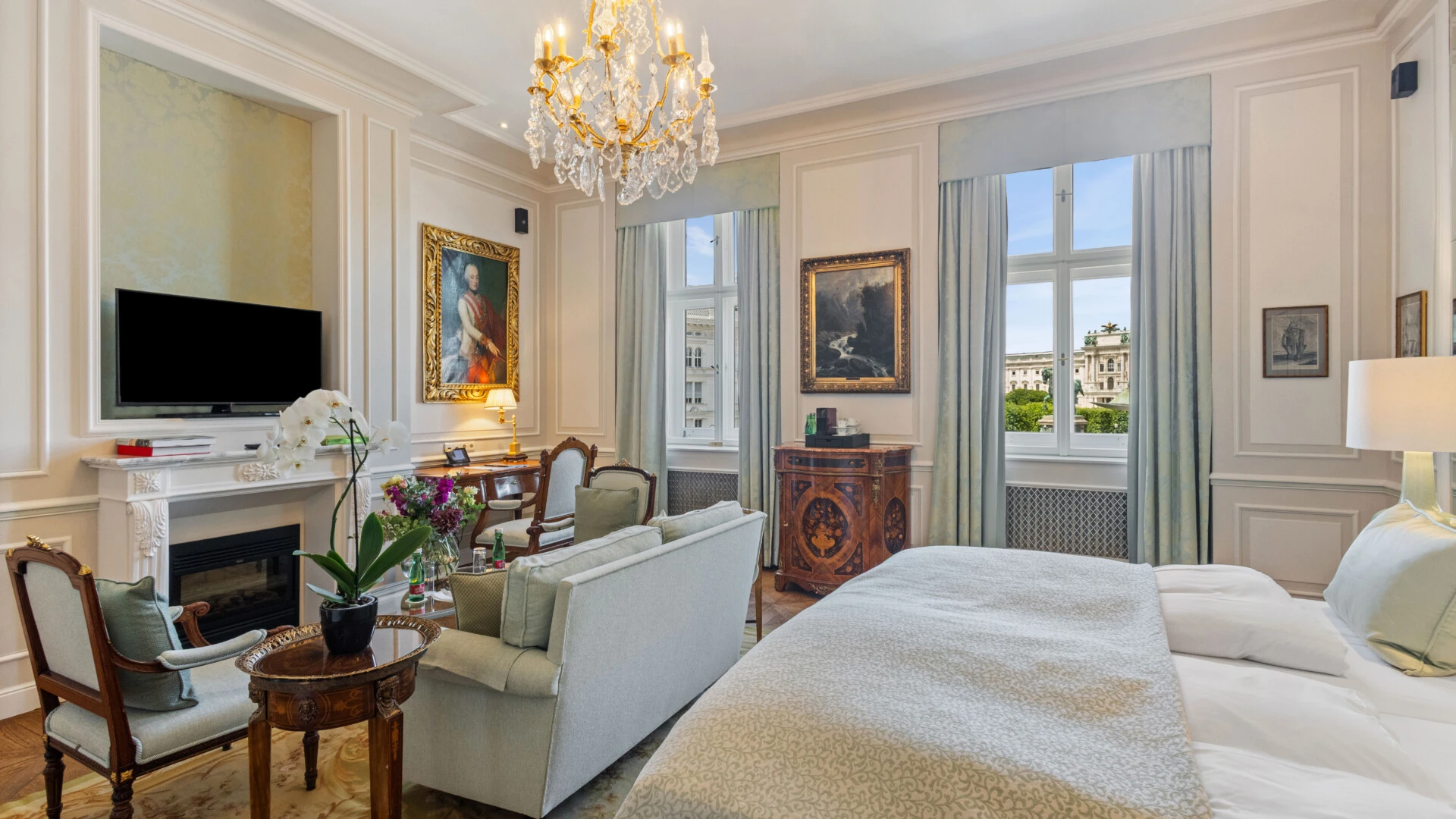 Eine wunderschön eingerichtete Hotelsuite mit einem weichen Bett, einem gemütlichen Kamin und einer eleganten Sitzecke, die klassischen Luxus ausstrahlt.