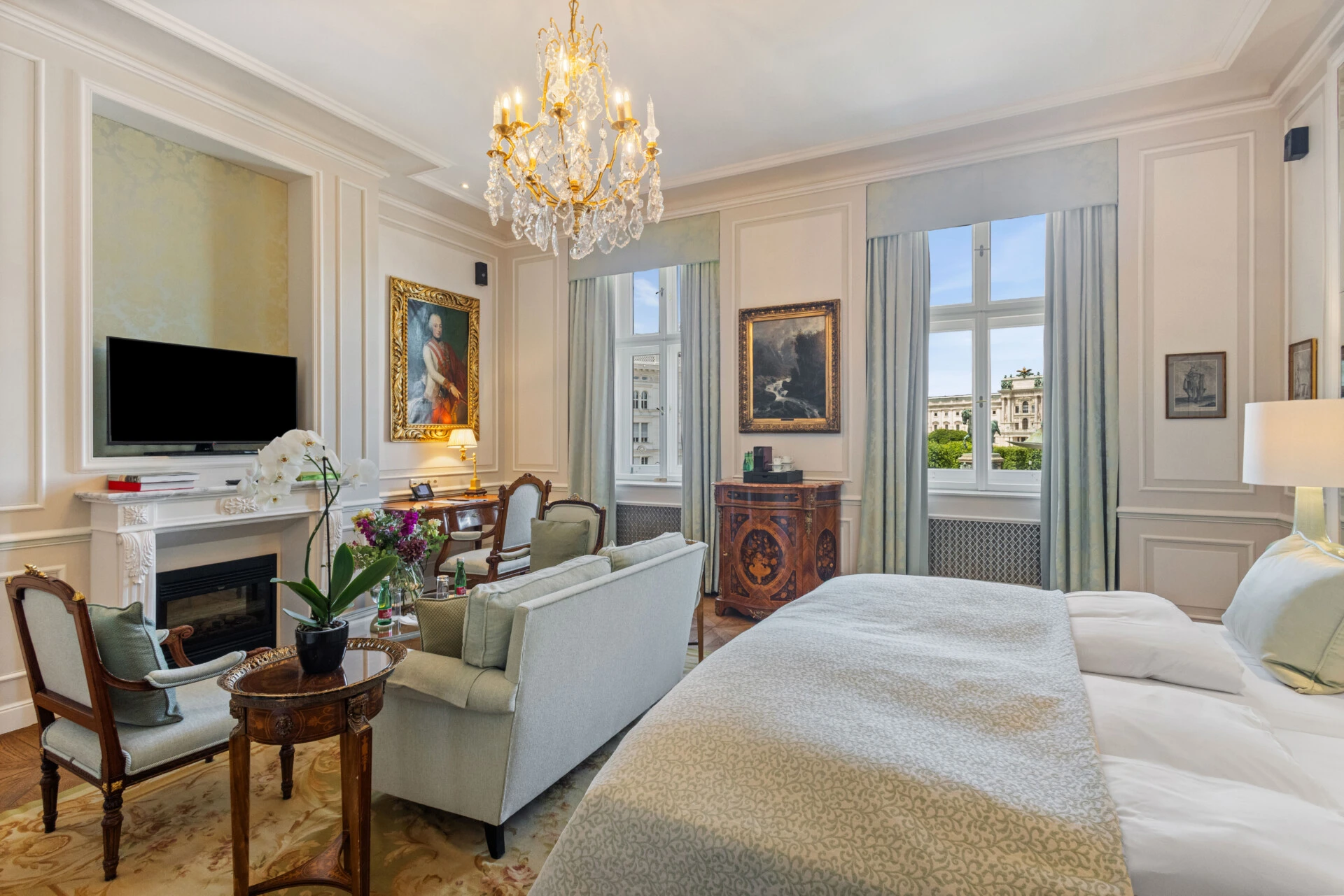 Eine wunderschön eingerichtete Hotelsuite mit einem weichen Bett, einem gemütlichen Kamin und einer eleganten Sitzecke, die klassischen Luxus ausstrahlt.