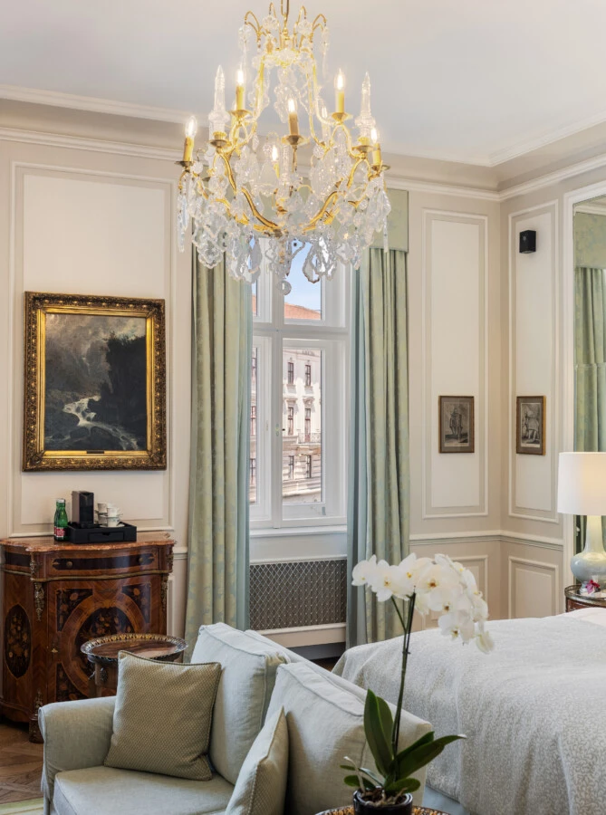 Ein wunderschönes Hotelzimmer mit klassischer Einrichtung und einem atemberaubenden Blick auf ein prächtiges Gebäude vom Fenster aus.