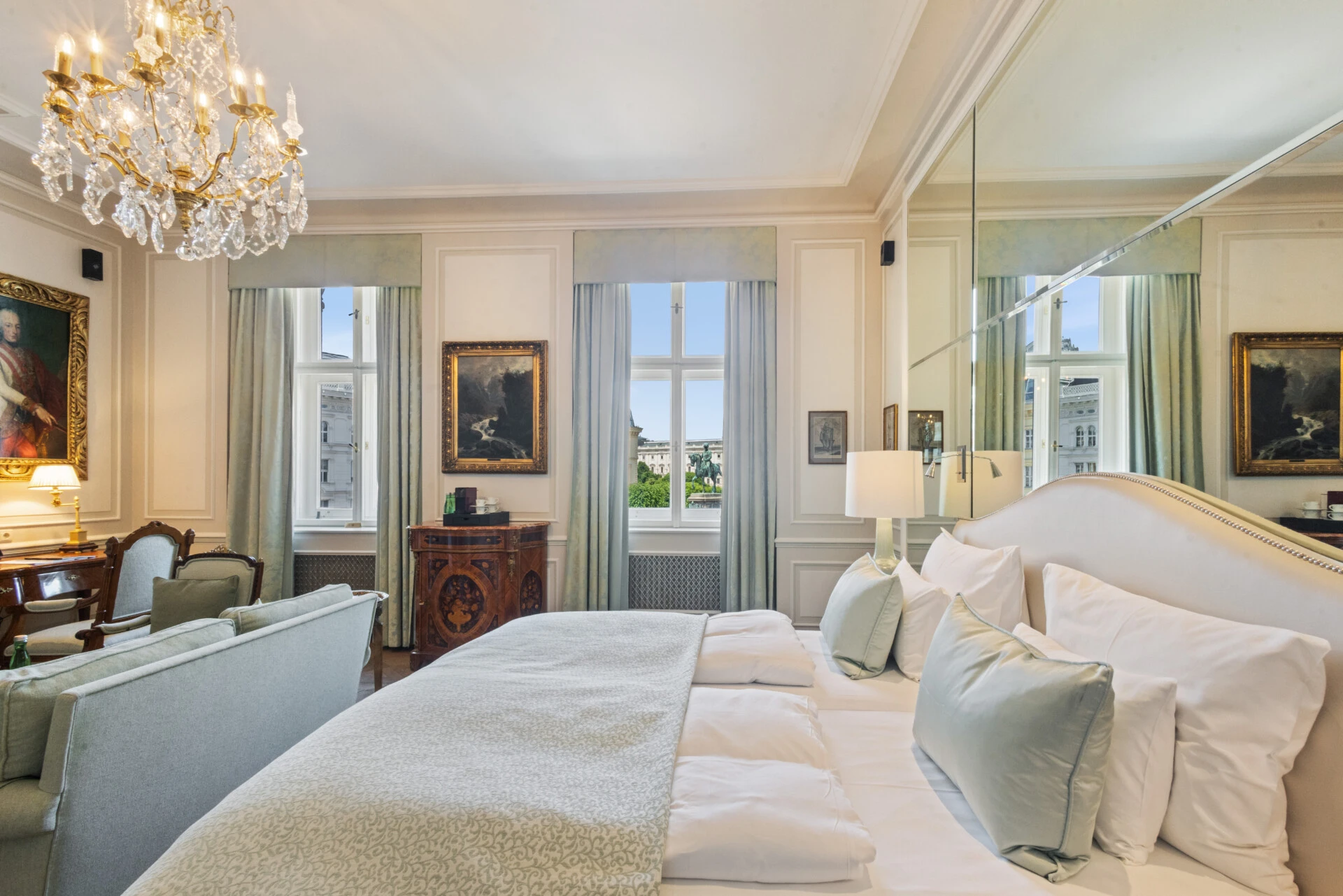 Ein wunderschönes Hotelzimmer mit klassischer Einrichtung und einem atemberaubenden Blick auf ein prächtiges Gebäude vom Fenster aus.