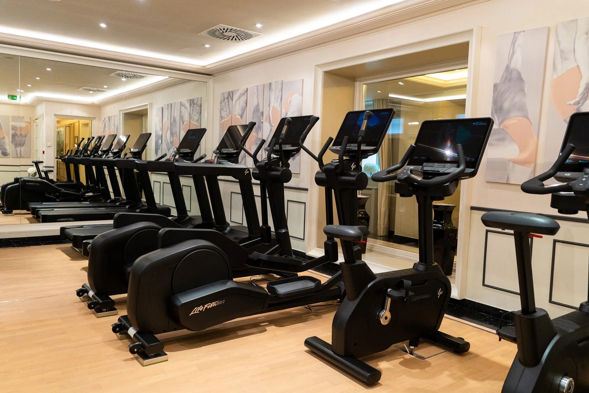 Modern ausgestatteter Fitnessraum mit Laufbändern, Crosstrainern und Fahrradergometern im Hotel Sacher Wien.