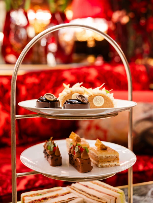 Zweistöckige Etagere für Afternoon Tea mit feinen Schokoladen-Törtchen und kleinen Sandwiches.