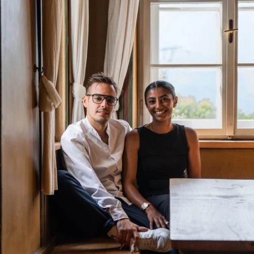 Ein Mann und eine Frau sitzen entspannt am Fenster, persönliche Atmosphäre, Tageslicht und elegantes Interieur