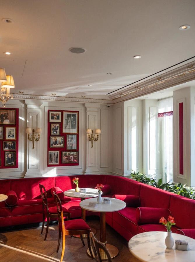 Stilvolle Sitzecke im Café Sacher Salzburg mit roten Polsterbänken und großen Fenstern