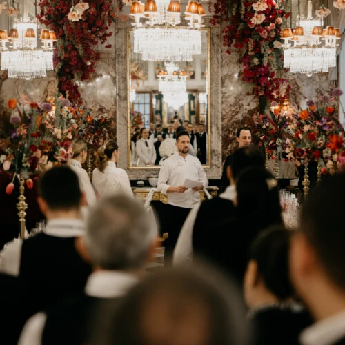 Festliche Ansprache vor Gästen und Mitarbeitenden im opulent dekorierten Marmorsaal des Hotel Sacher während der Vorbereitungen zum Wiener Opernball