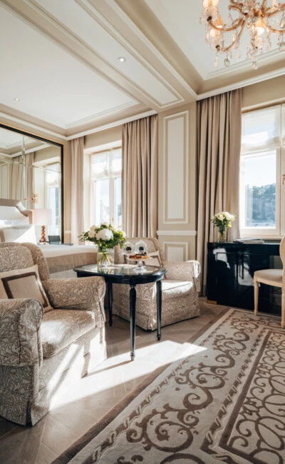 Deluxe Zimmer mit Ausblick im Hotel Sacher Salzburg mit elegantem Sitzbereich, klassischen Möbeln und großen Fenstern mit Aussicht auf die Salzburger Altstadt