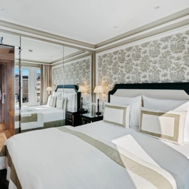 Schlafzimmer der Signature Suite mit Ausblick im Hotel Sacher Salzburg, mit klassischem Interieur, großem Spiegel und angrenzendem Marmorbad