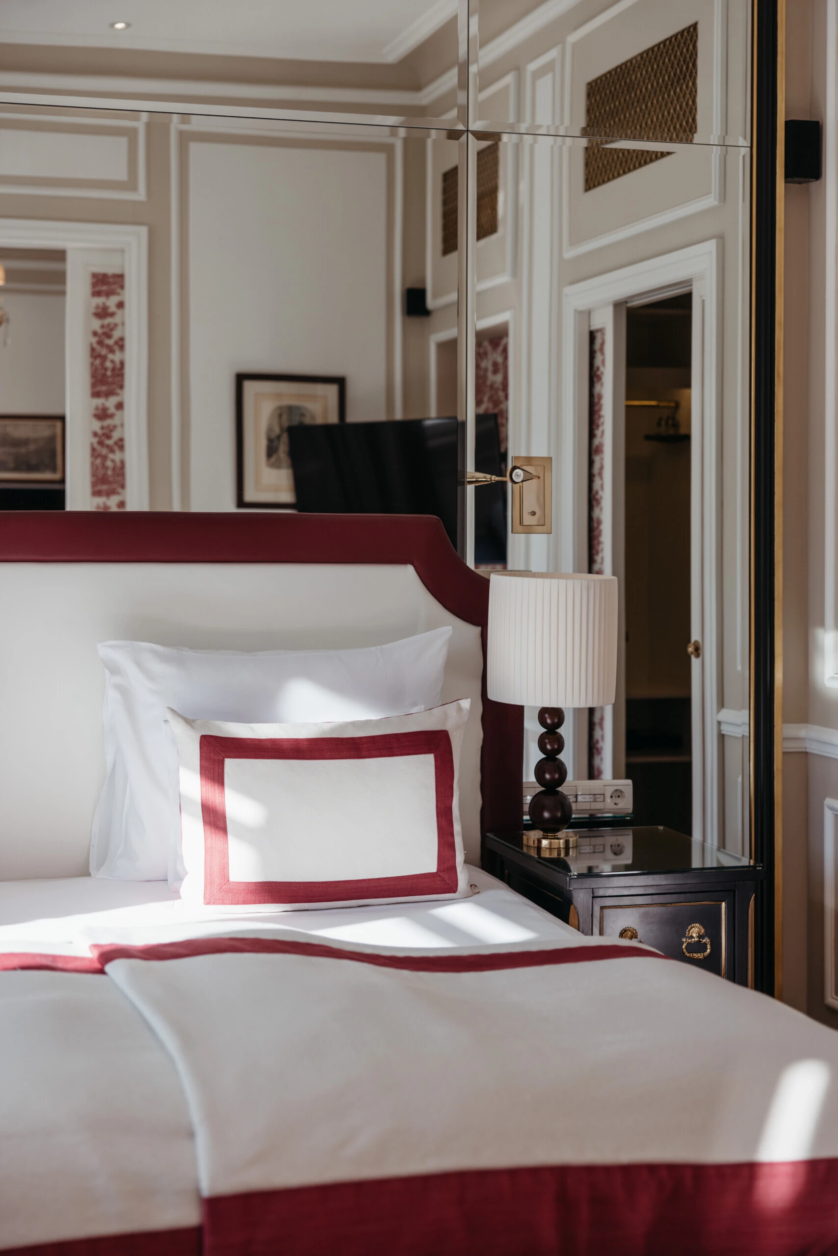 Nahaufnahme des Betts in der Familiensuite mit Ausblick im Hotel Sacher Salzburg, mit roten Designdetails und klassischem Interieur