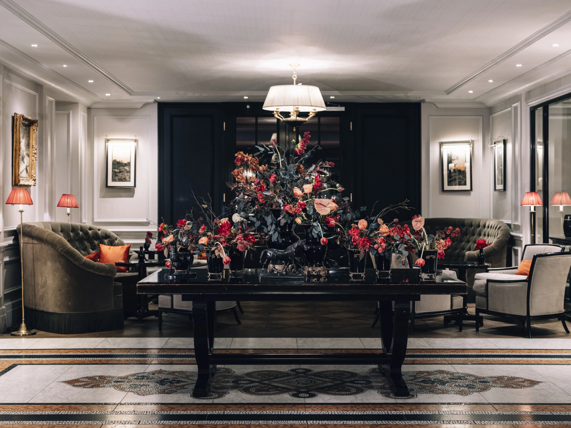 Elegante Lobby des Hotel Sacher Salzburg mit Blumenarrangement und klassischen Sitzmöbeln.