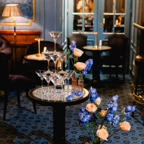 Champagnergläser und florale Hochzeitsdekoration in der Blauen Bar des Hotel Sacher Wien.