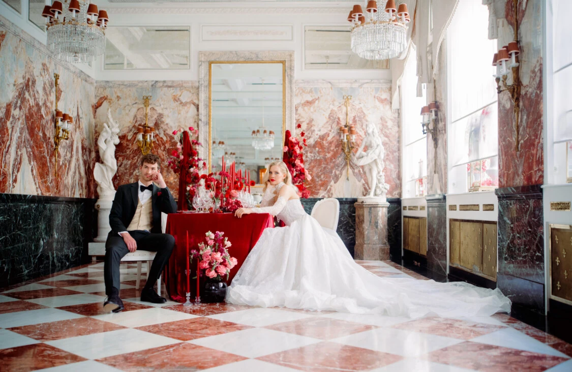 Brautpaar an einer festlich dekorierten Hochzeitstafel im Marmorsaal des Hotel Sacher Wien.
