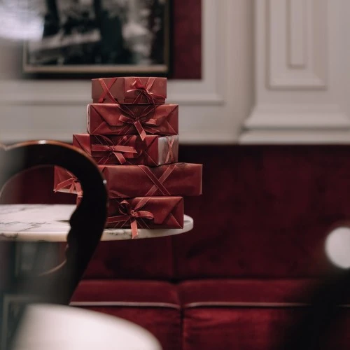 Presents wrapped in deep red papers on top of each other on a marble table in Hotel Sacher.