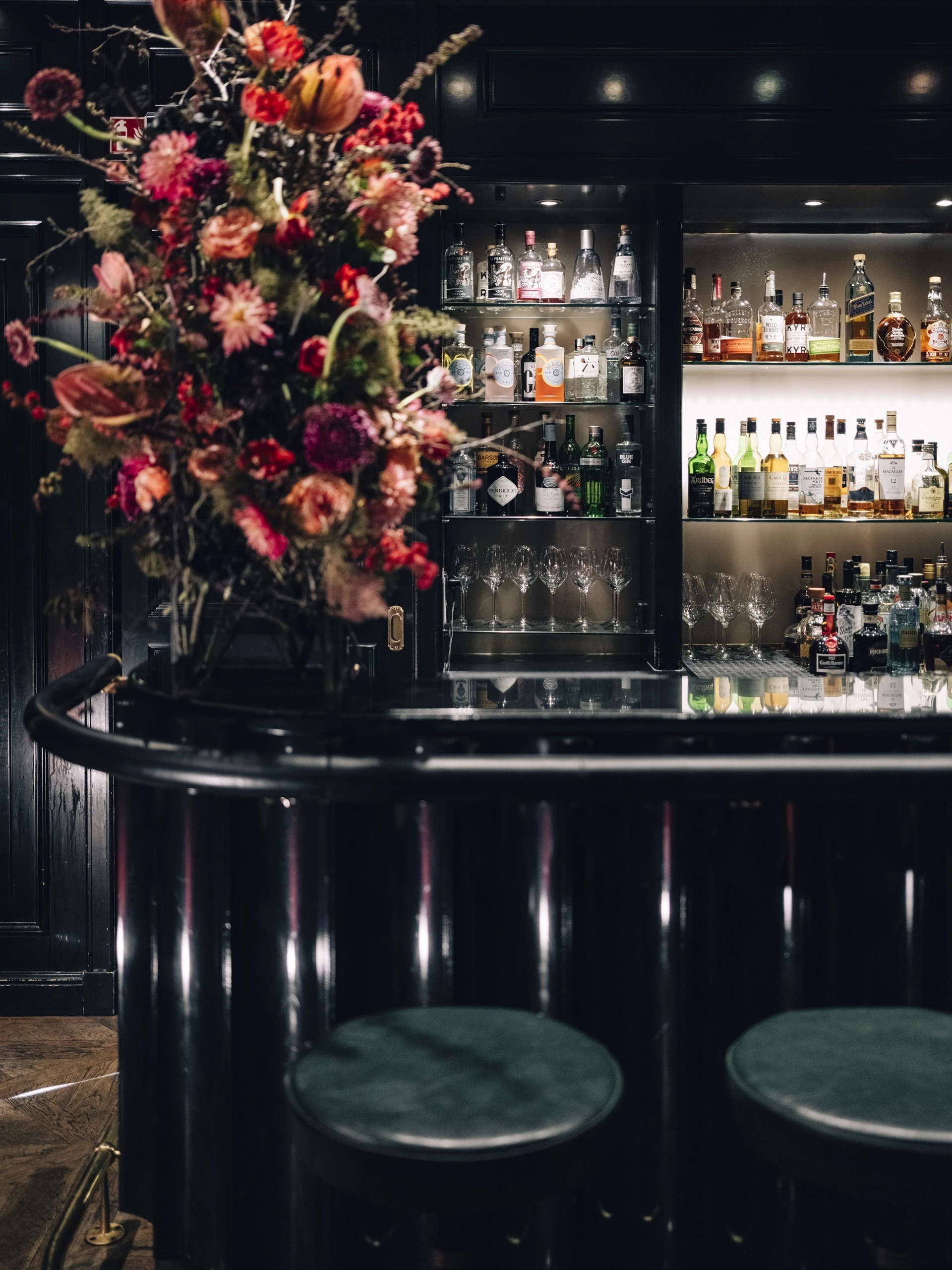 This richly decorated space is the Sacher Bar at Hotel Sacher Salzburg, exuding timeless elegance with its classic paneling, ornate chandelier, and refined blend of cream, gold, and red tones that reflect the hotel’s signature style.