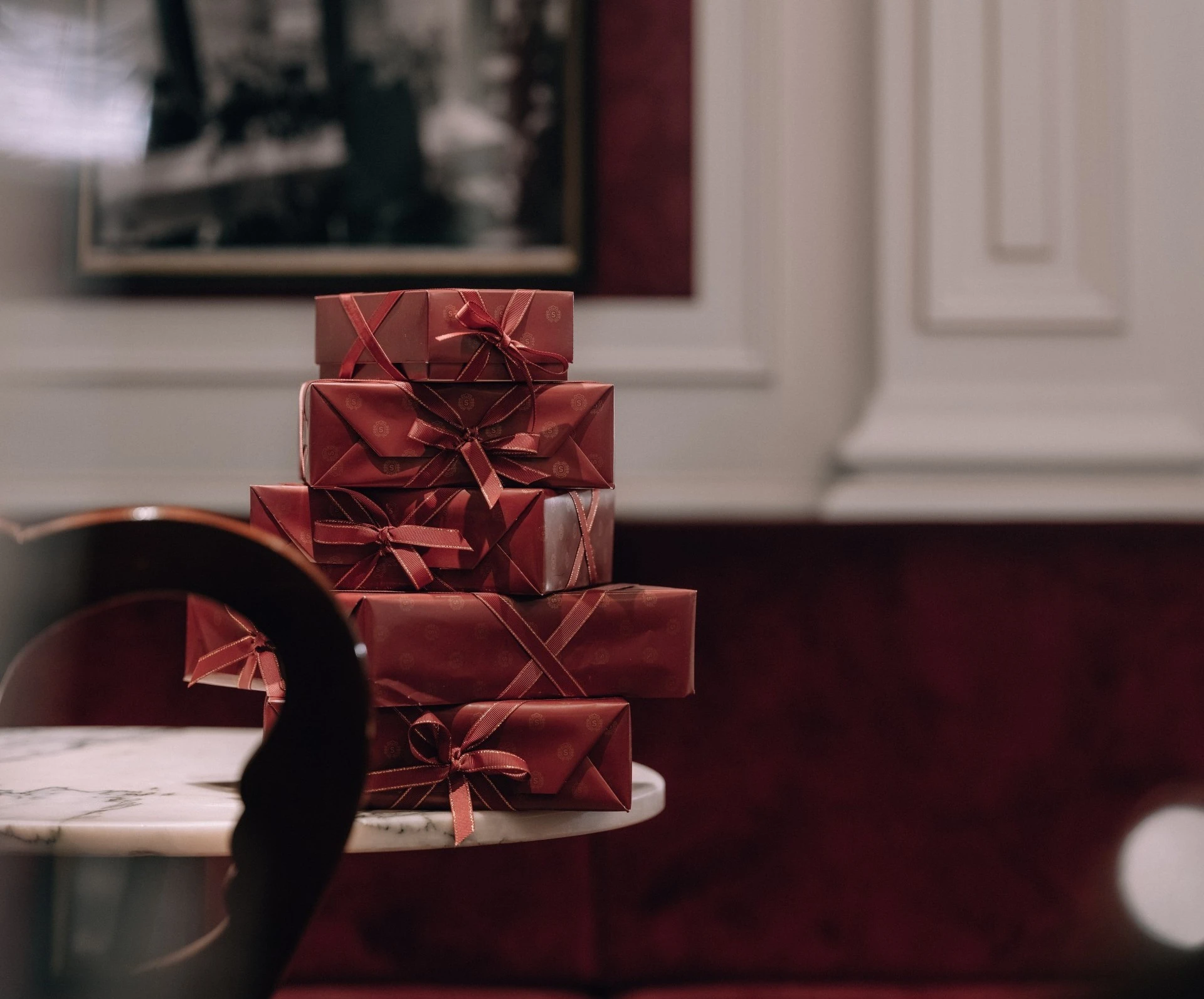 Presents wrapped in deep red papers on top of each other on a marble table in Hotel Sacher.