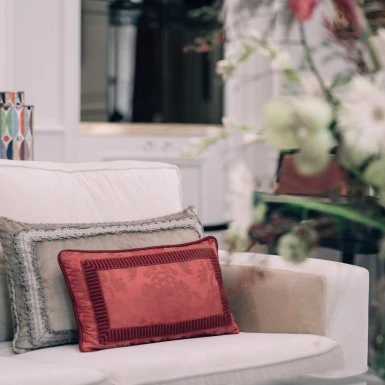 Elegant red pillow on comfortable sofa in the Madame Butterfly Suite at Hotel Sacher Wien.