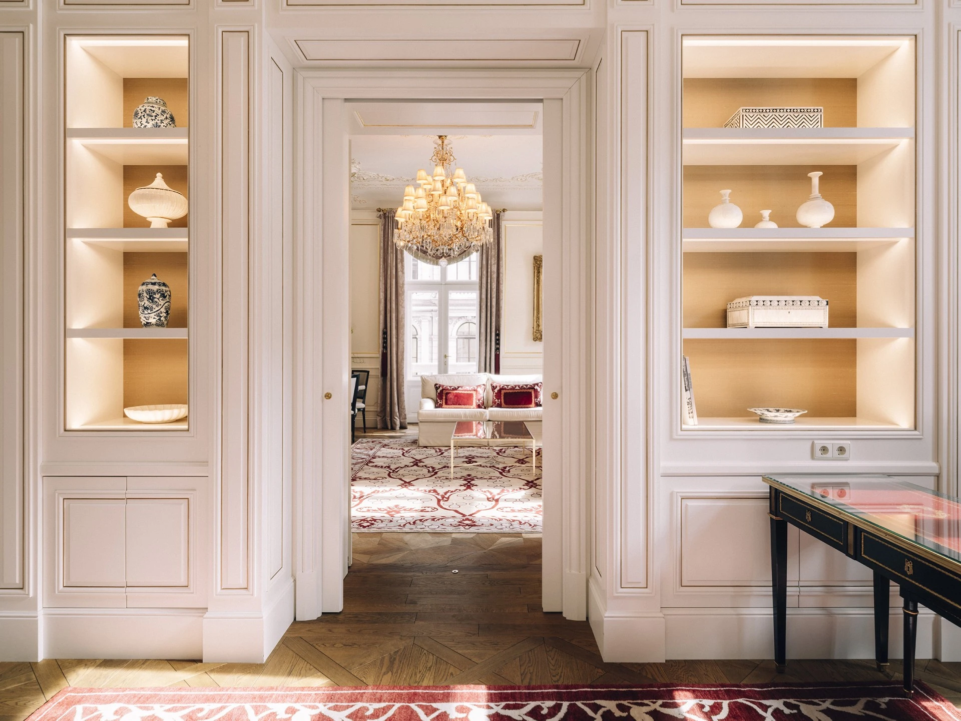 Philharmoniker Suite at Hotel Sacher Wien, a spacious and elegantly designed suite with refined decor, including antique furniture and a beautiful chandelier, creating a sophisticated and luxurious atmosphere.