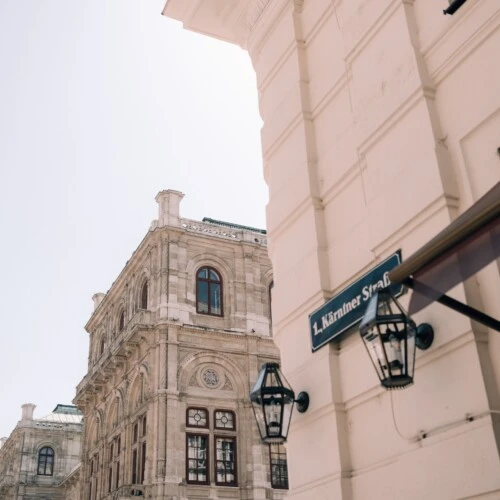 Street view of Vienna's iconic buildings, with ornate facades and architectural details and a street sign "Kärntner Straße".