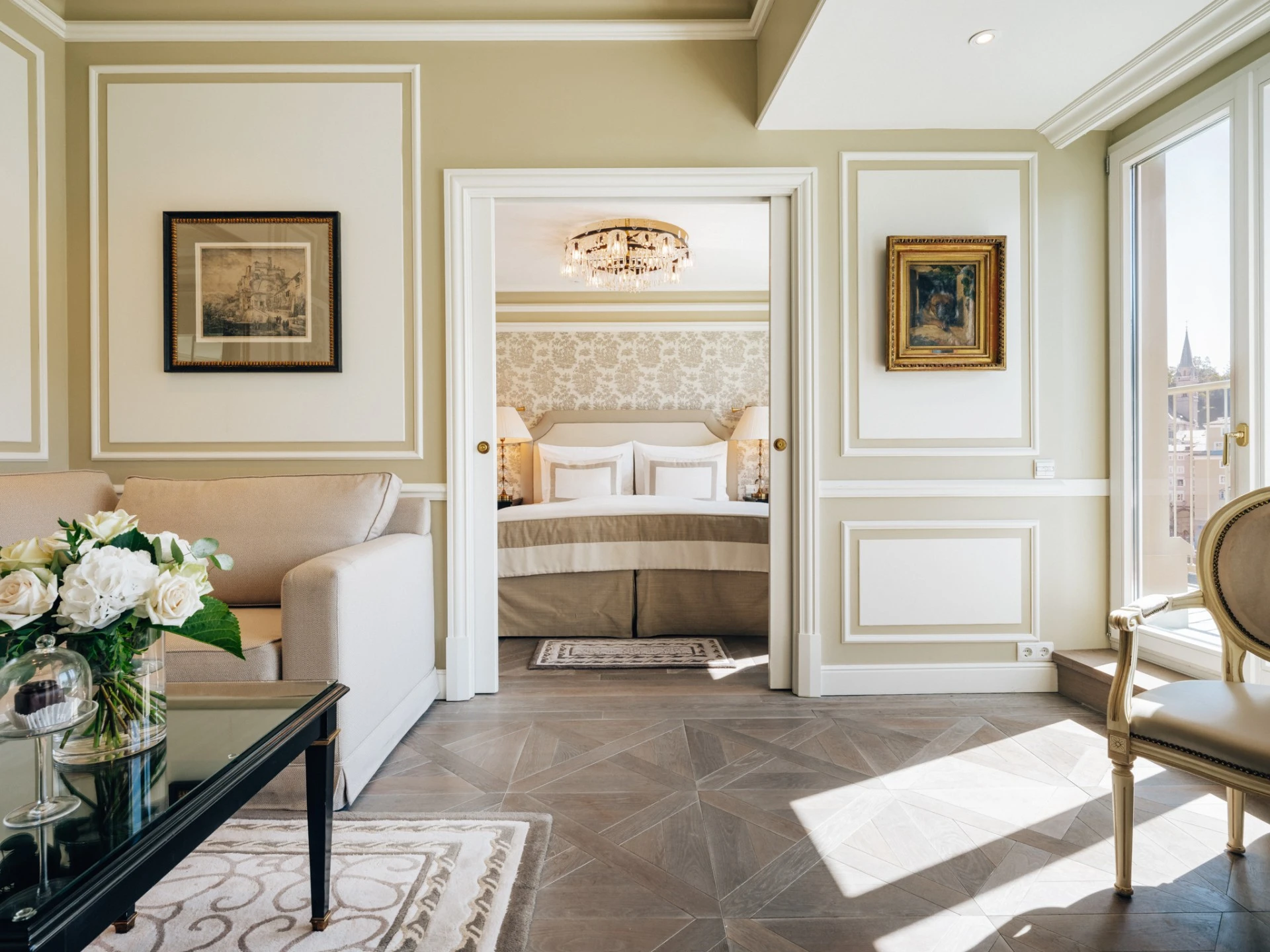 Presidential Suite at Hotel Sacher Salzburg with a bed in the centre featuring upscale decor, golden details and ample light.