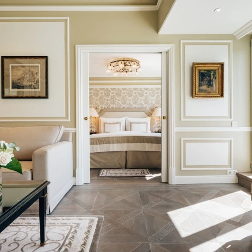 Presidential Suite at Hotel Sacher Salzburg with a bed in the centre featuring upscale decor, golden details and ample light.