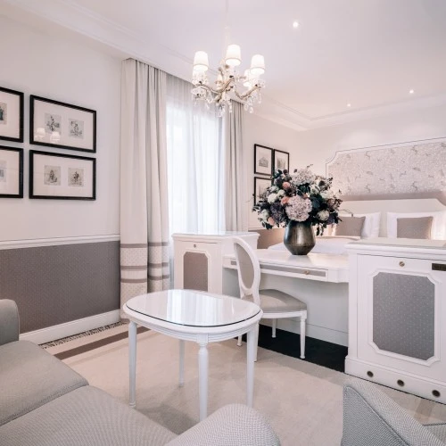 This elegant suite at Hotel Sacher Salzburg features classic decor with soft hues, floral arrangements, and timeless charm.