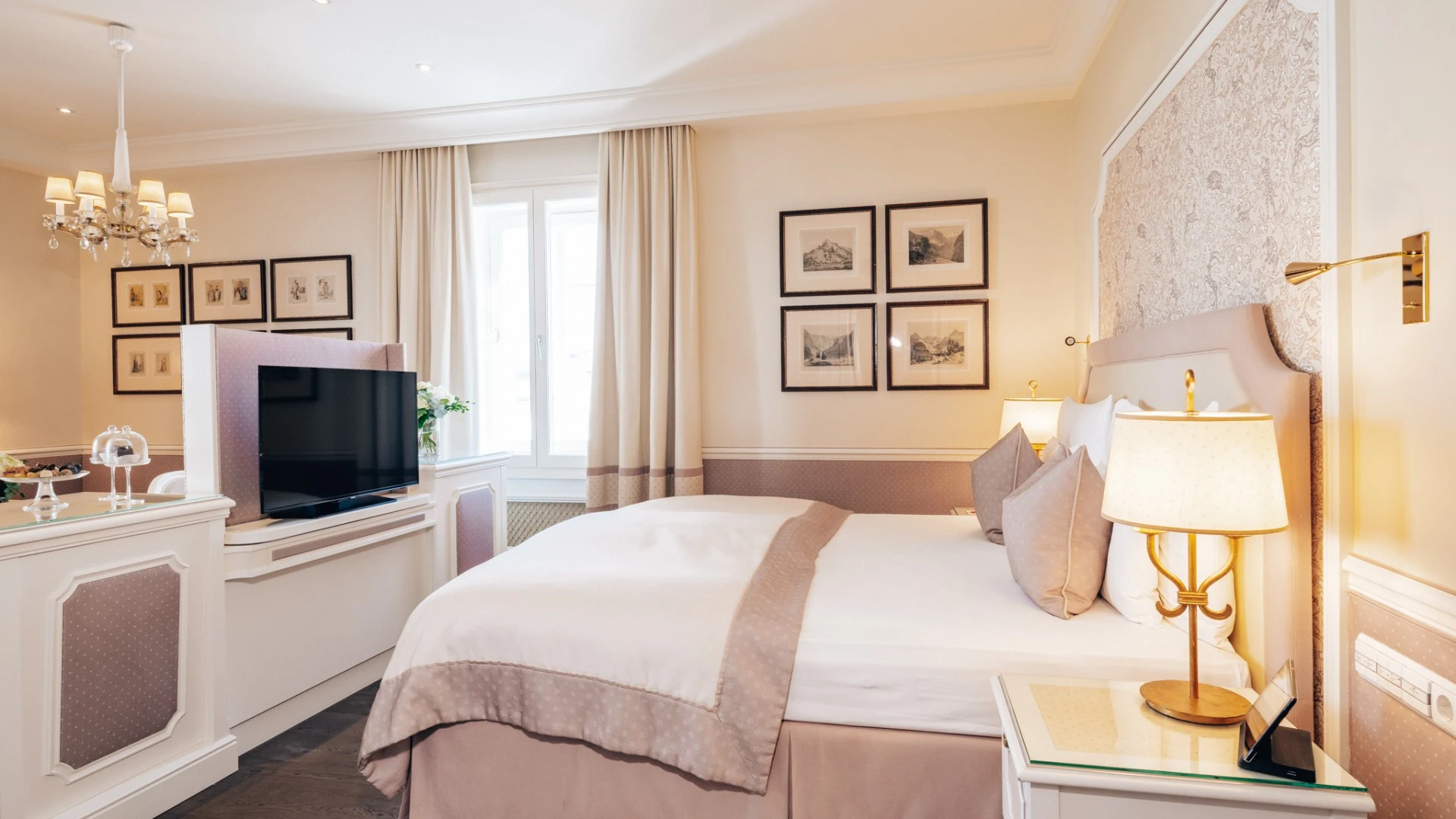 A serene guest room at Hotel Sacher Salzburg blends soft neutrals, classic artwork, and elegant details for timeless comfort.