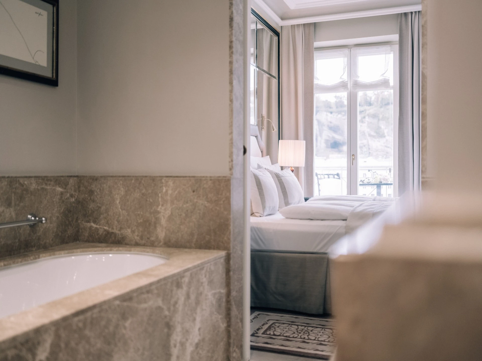 A luxurious guestroom at Hotel Sacher, blending classic elegance with modern comfort and a view over Salzburg.