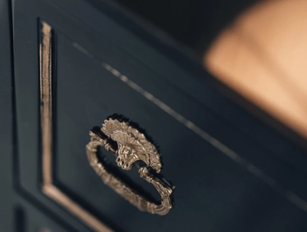 A warm, ambient glow from a sculptural floor lamp softly illuminates the classic paneled walls of a refined space in Hotel Sacher Salzburg.