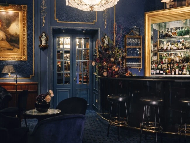The opulent charm of the Blaue Bar at Hotel Sacher Wien, with its deep blue palette, ornate gold accents, and intimate old-world ambiance.