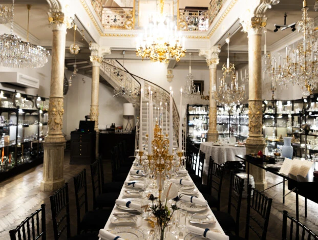 An elegant evening unfolds under a stunning Lobmeyr chandelier, where timeless design meets exquisite dining.
