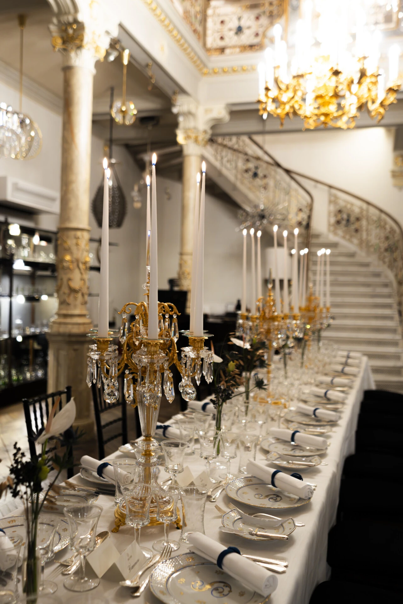 An elegant evening unfolds under a stunning Lobmeyr chandelier, where timeless design meets exquisite dining.