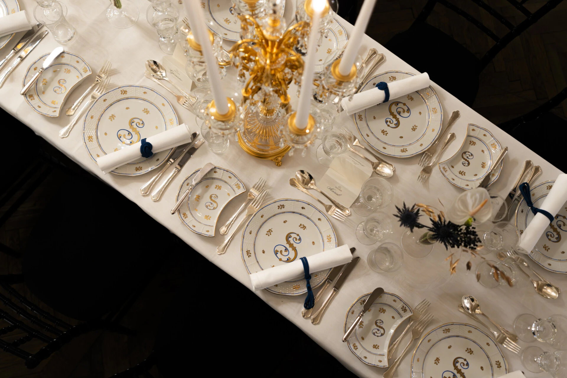 An elegant evening unfolds under a stunning Lobmeyr chandelier, where timeless design meets exquisite dining.