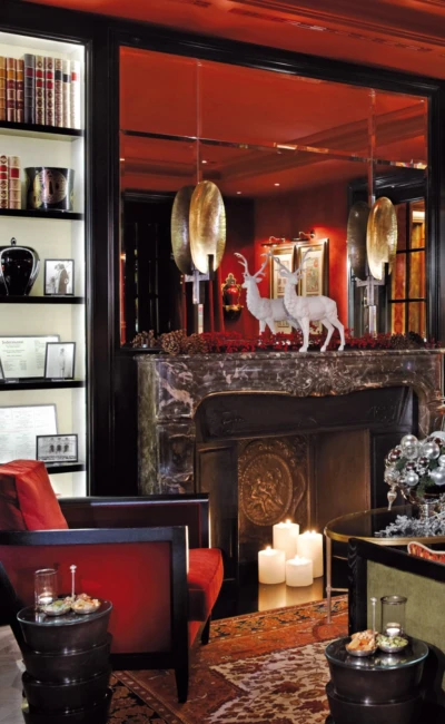 Elegant hotel Sacher Salzburg Bar with dark wood interior, velvet armchairs, fireplace, and festive holiday decorations