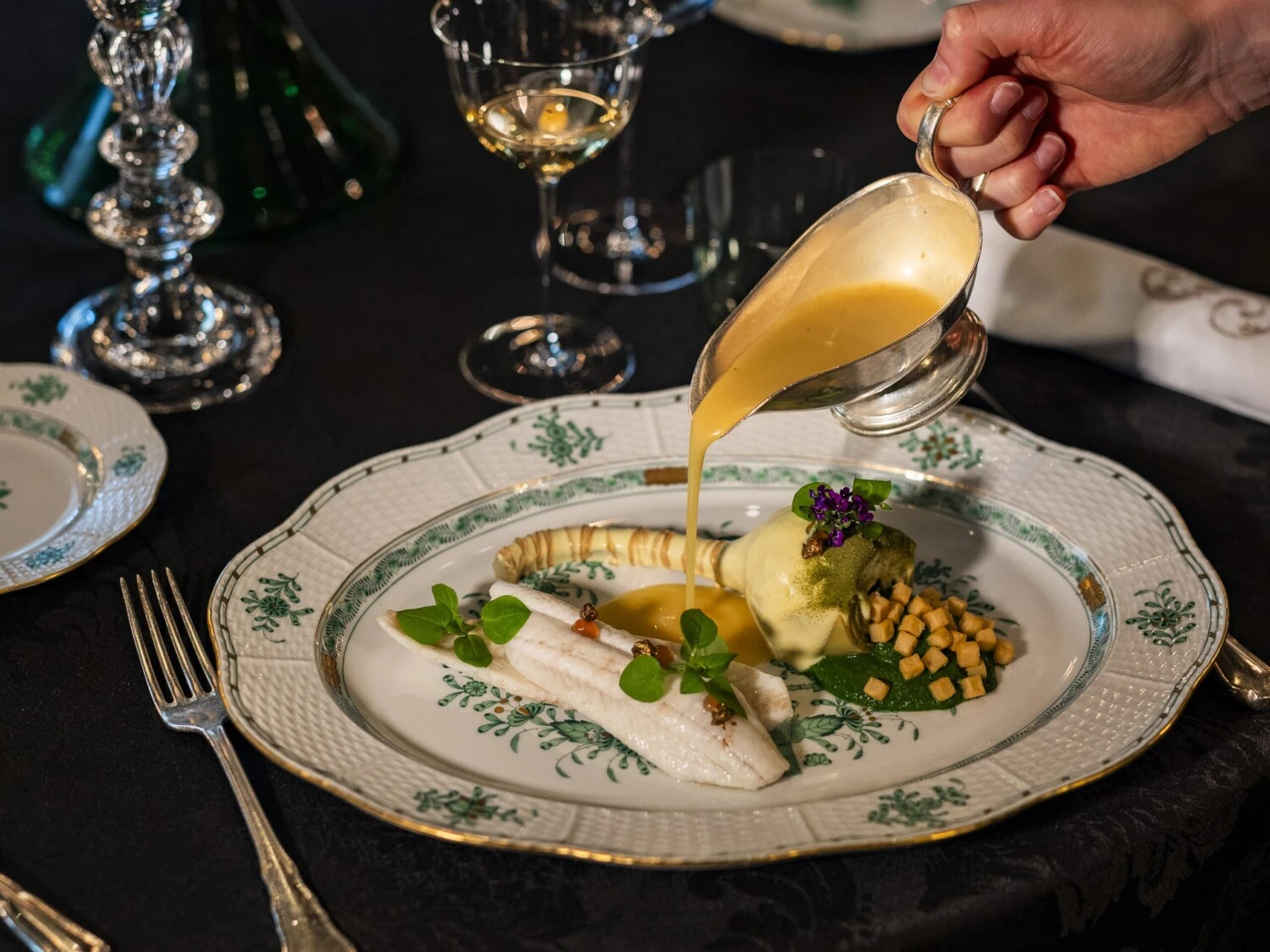 A sauce being poured over a fish dish