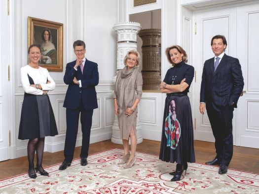 Professional portrait of the Sacher family, renowned hotel owners, in an elegant, traditionally decorated room