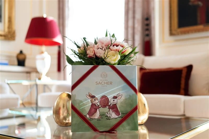 Original Sacher Torte Easter edition with rabbit motif and flowers in an elegant living room setting