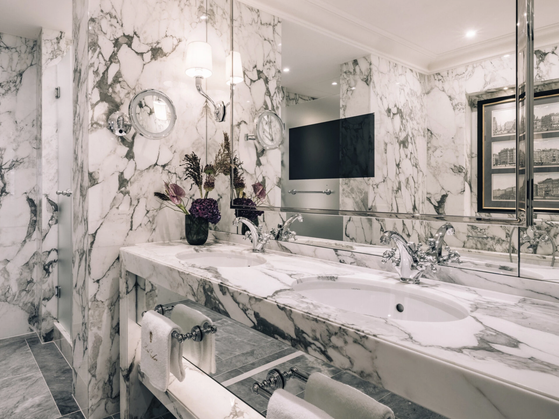 Luxury marble bathroom at Hotel Sacher Vienna with double sink, large mirror, elegant lighting and classic five-star hotel design.